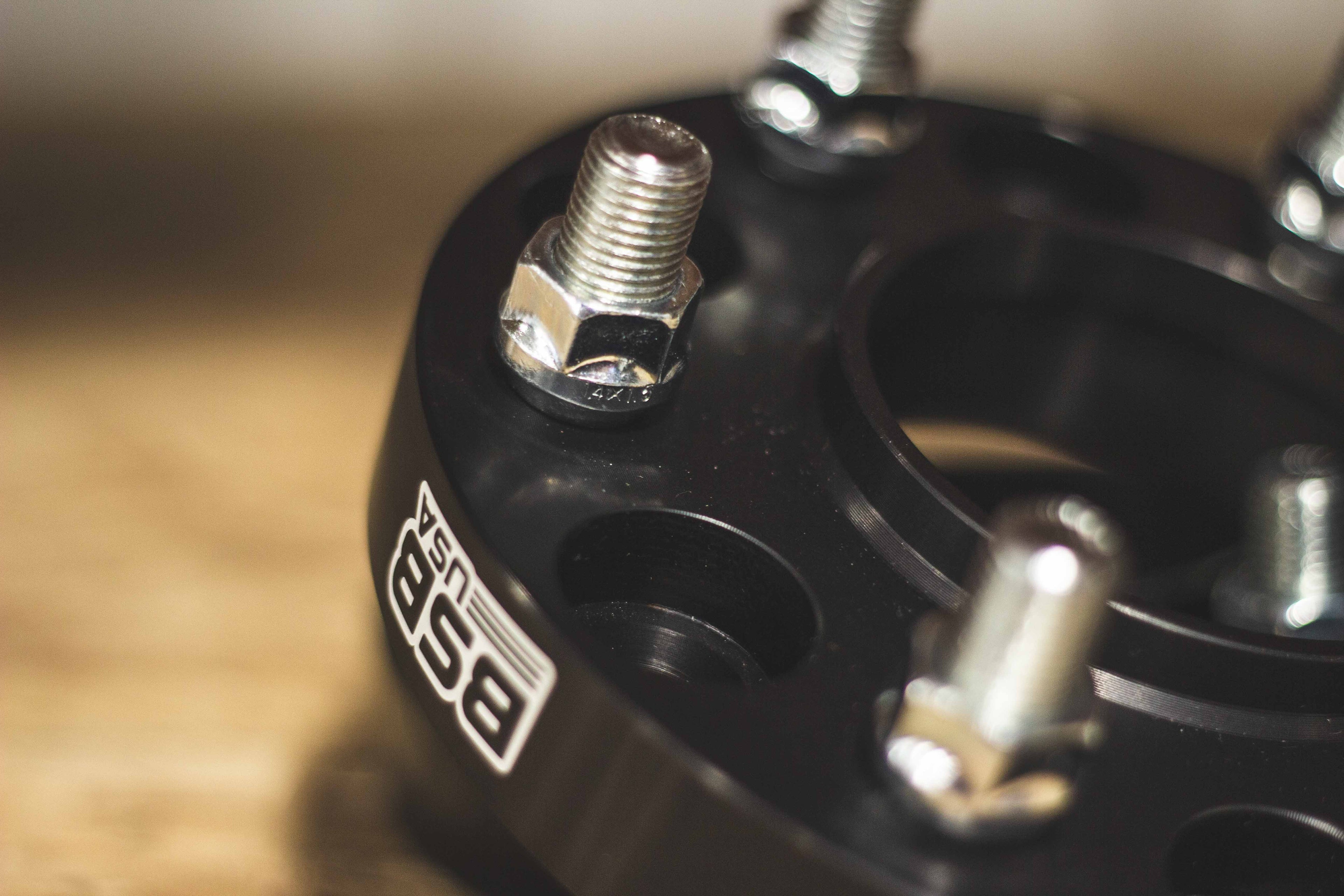 Closeup photo of a BSB USA billet aluminum wheel spacer showcasing the high strength steel pressed-in studs.