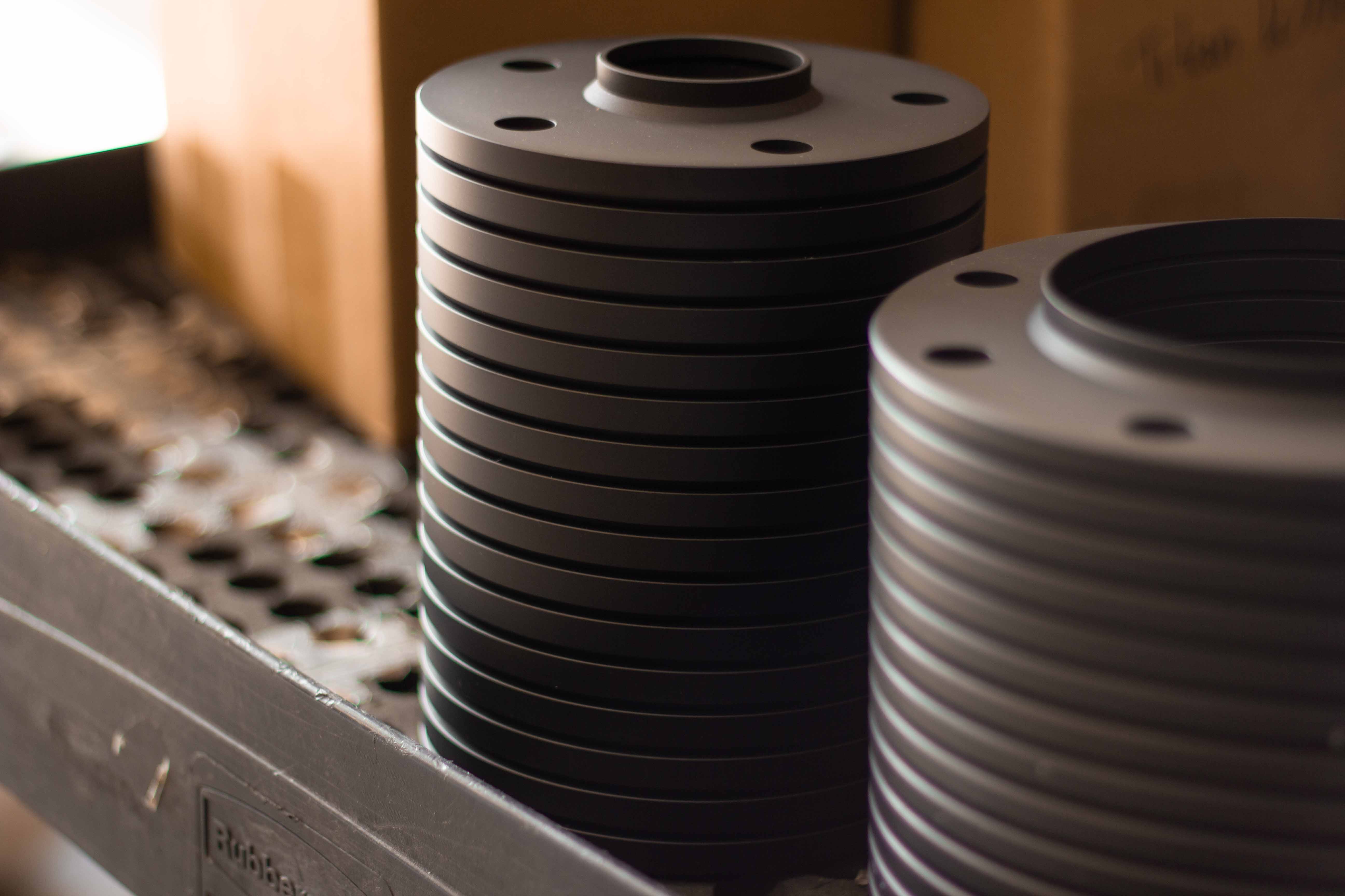 Stack of anodized aluminum wheel spacers, ready for engraving at BSB USA.