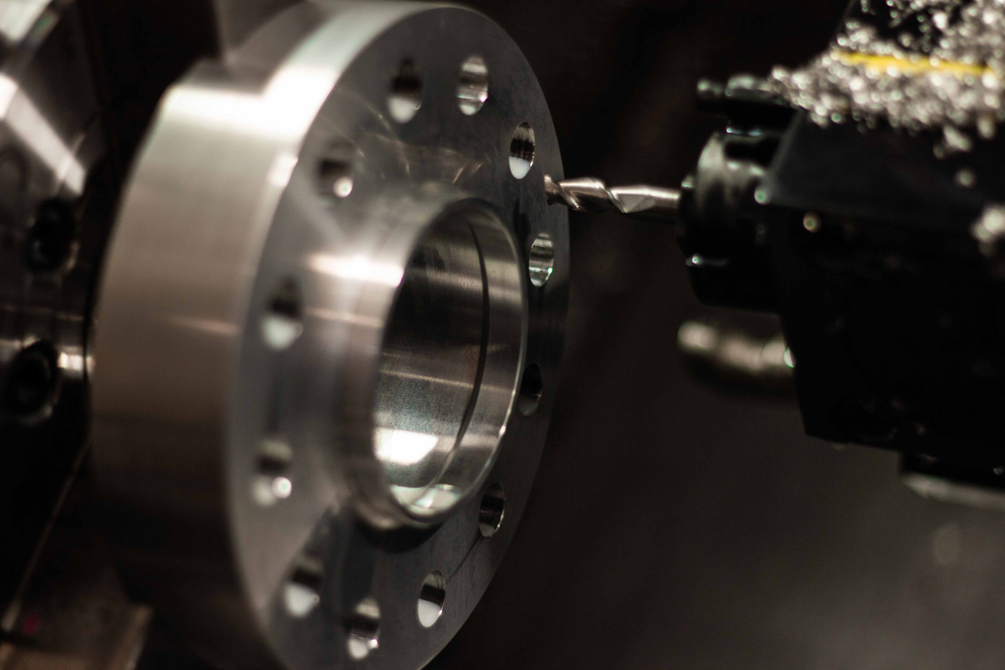Partially machined billet aluminum wheel spacer set up on a CNC lathe inside an American machine shop for BSB USA production.