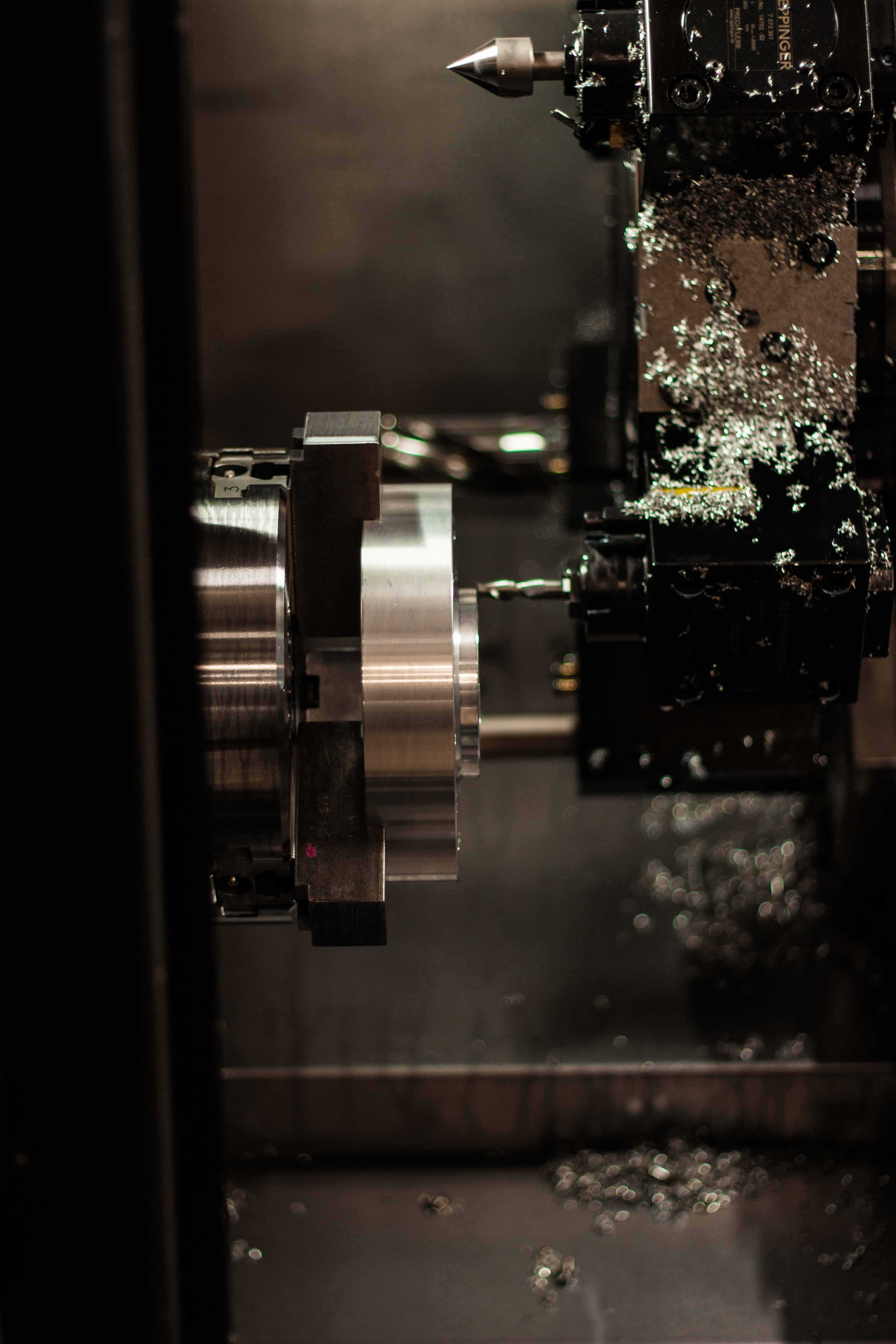 Close-up of a metal lathe in operation with metal shavings.
