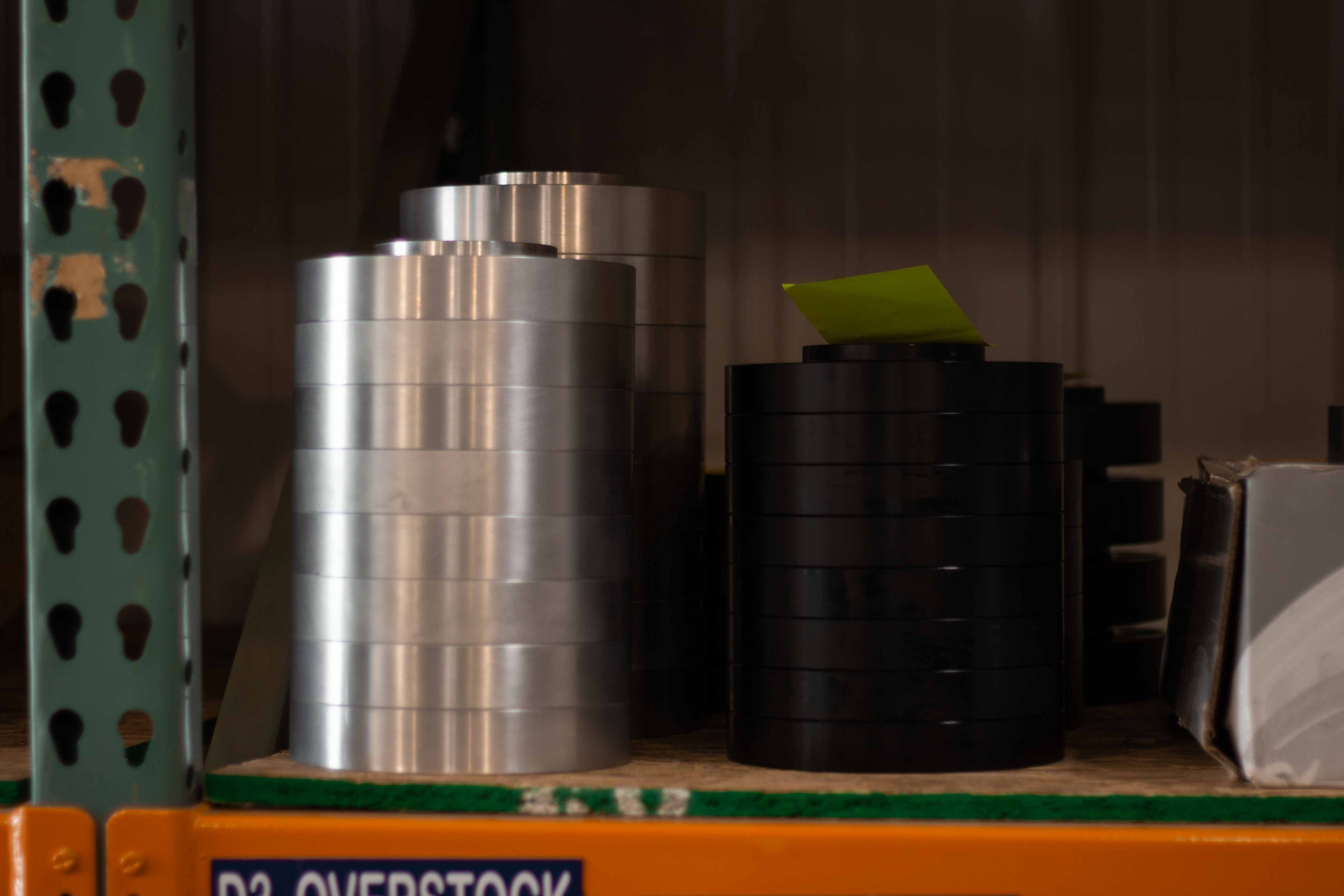 Stacks of machined billet aluminum wheel spacers ready for stud installation at BSB USA.