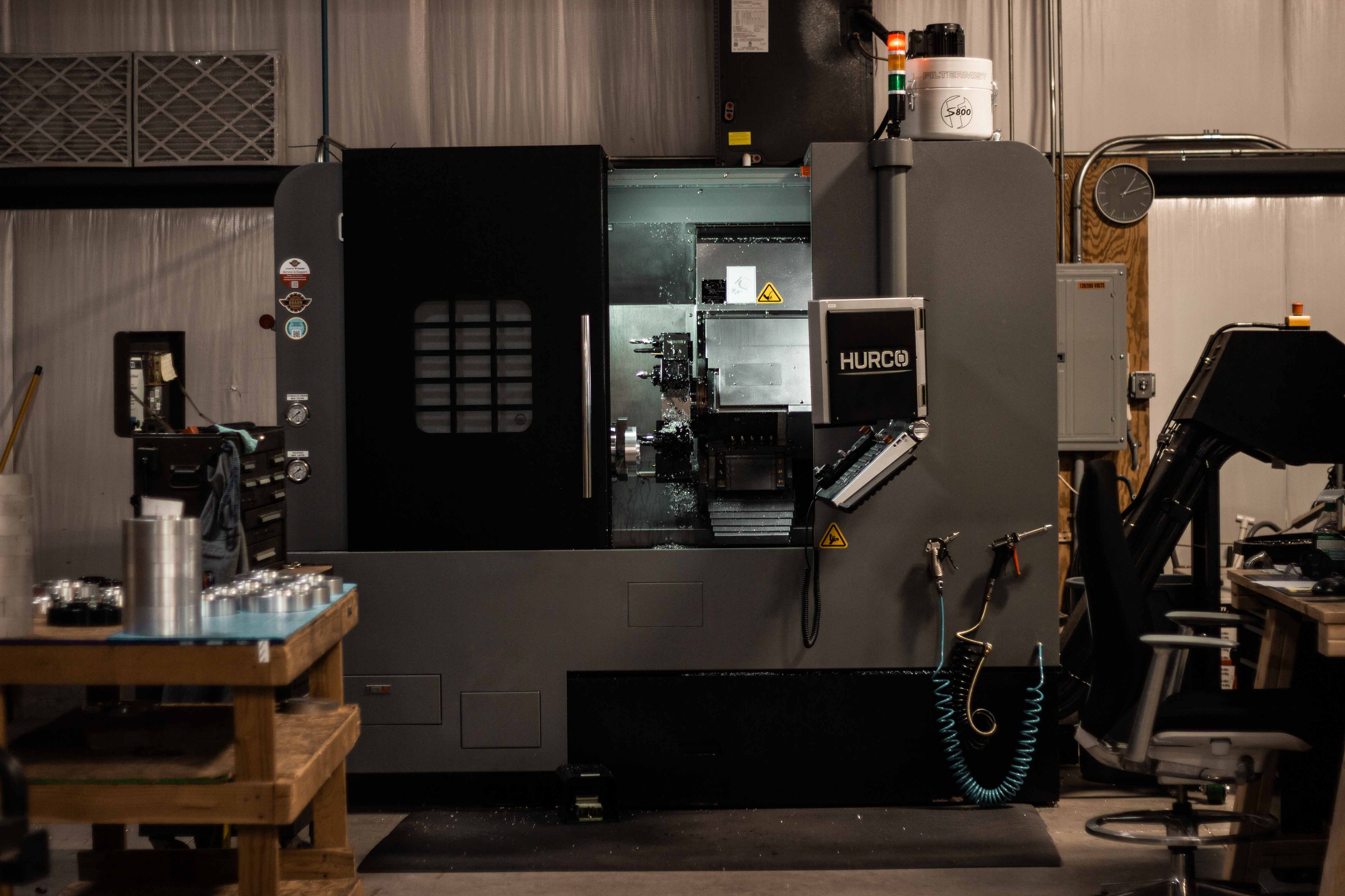 View inside BSB USA’s American machine shop showing a CNC lathe machining a billet aluminum wheel spacer.