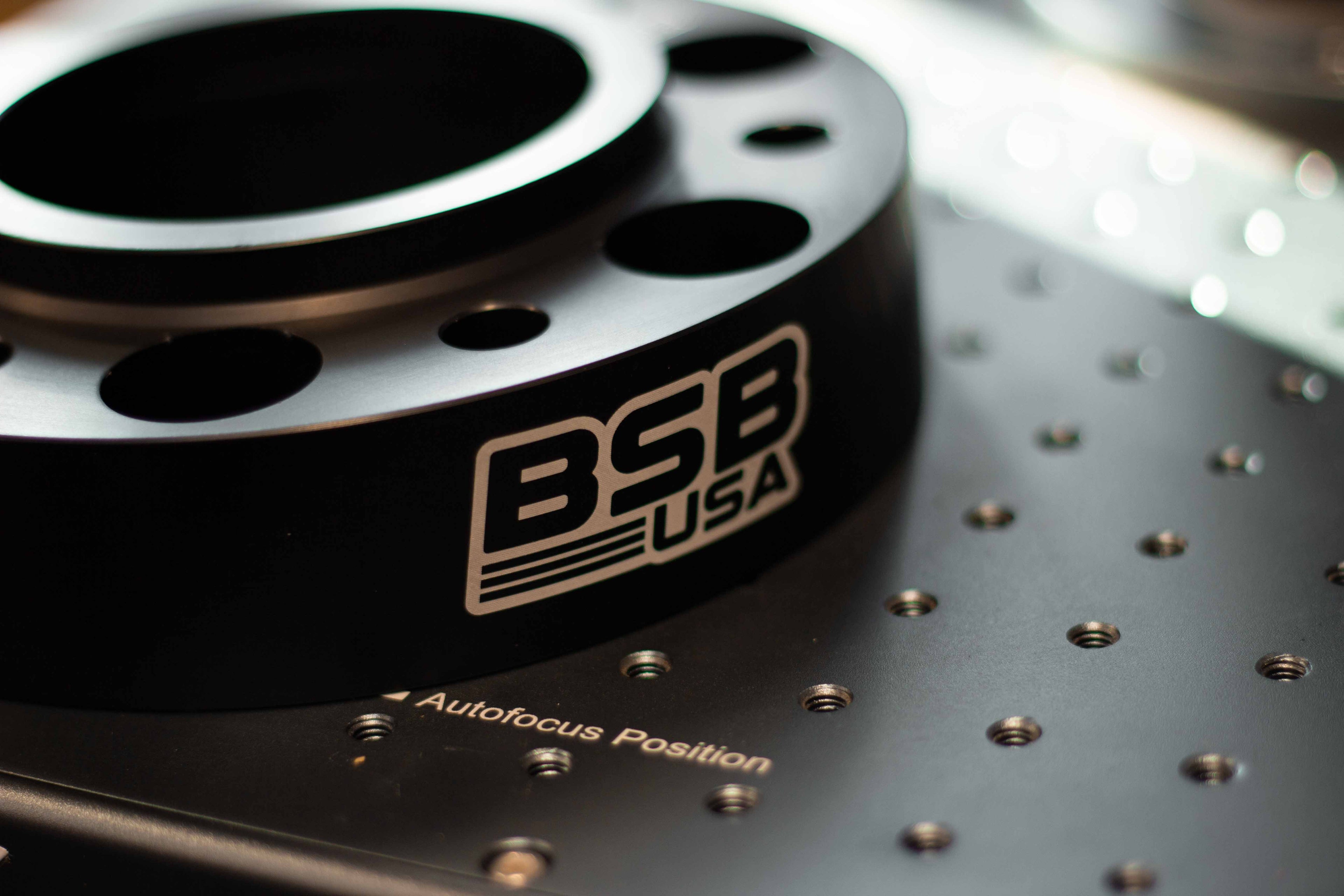Close-up of the BSB USA logo laser-engraved on a billet aluminum wheel spacer.