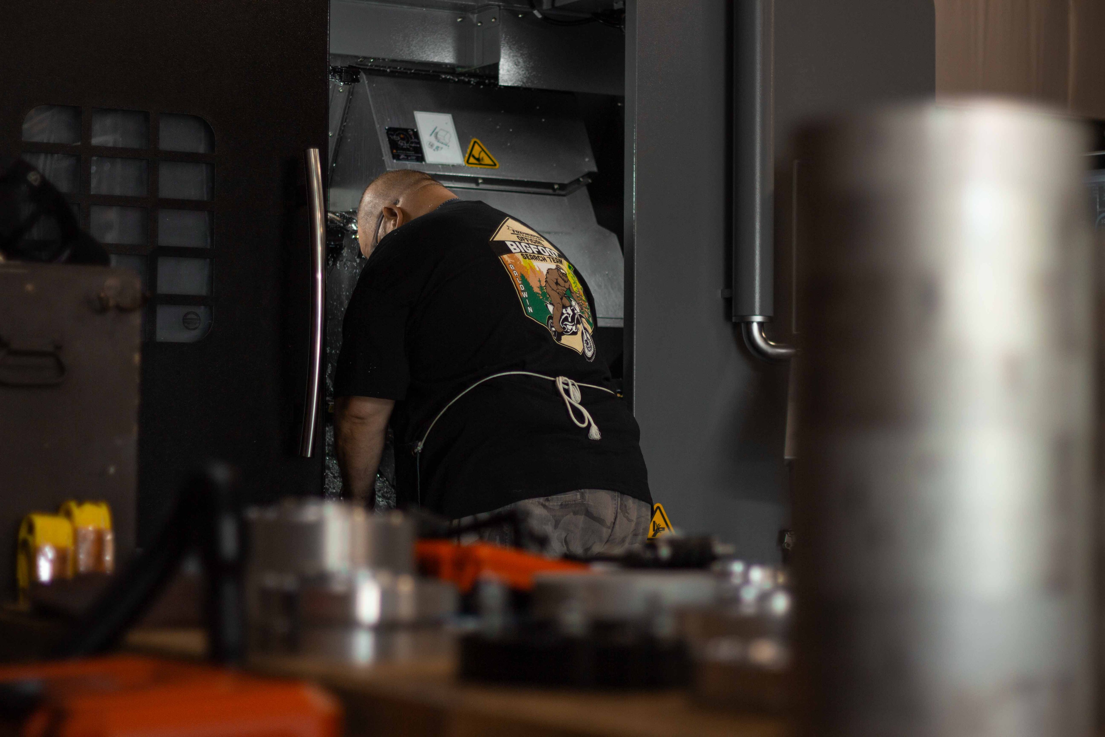 Machinist working inside CNC machine at BSB USA's shop.