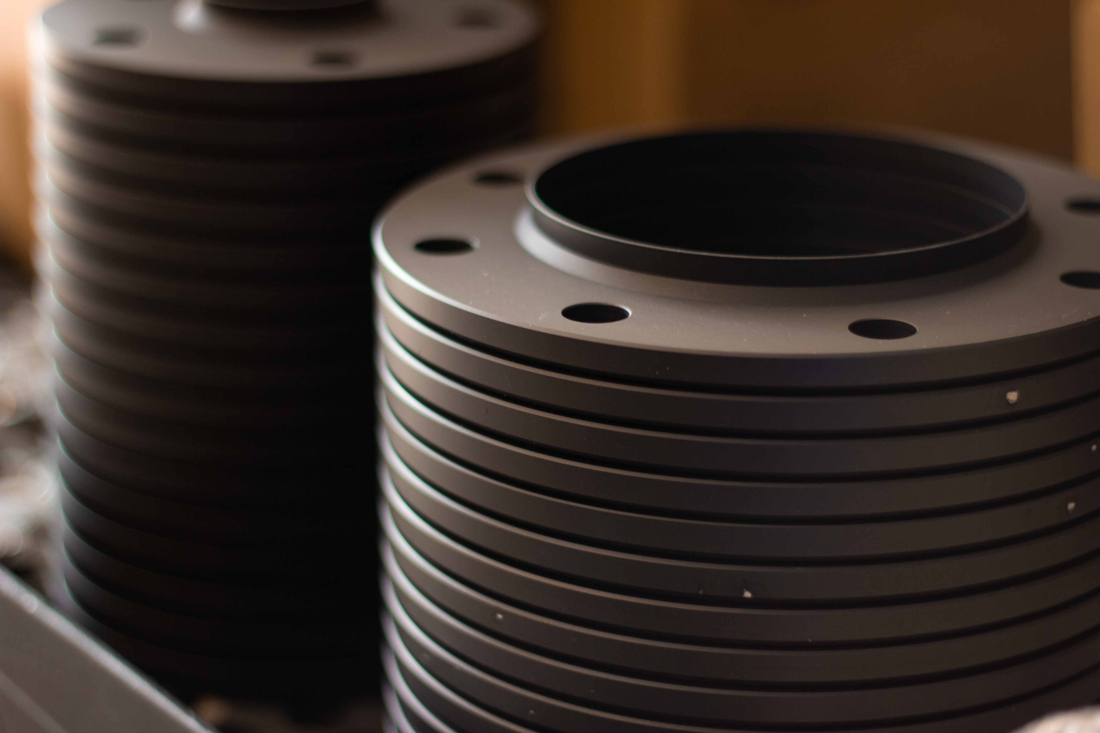 Stack of finished anodized billet aluminum slip-on wheel spacers manufactured by BSB USA.