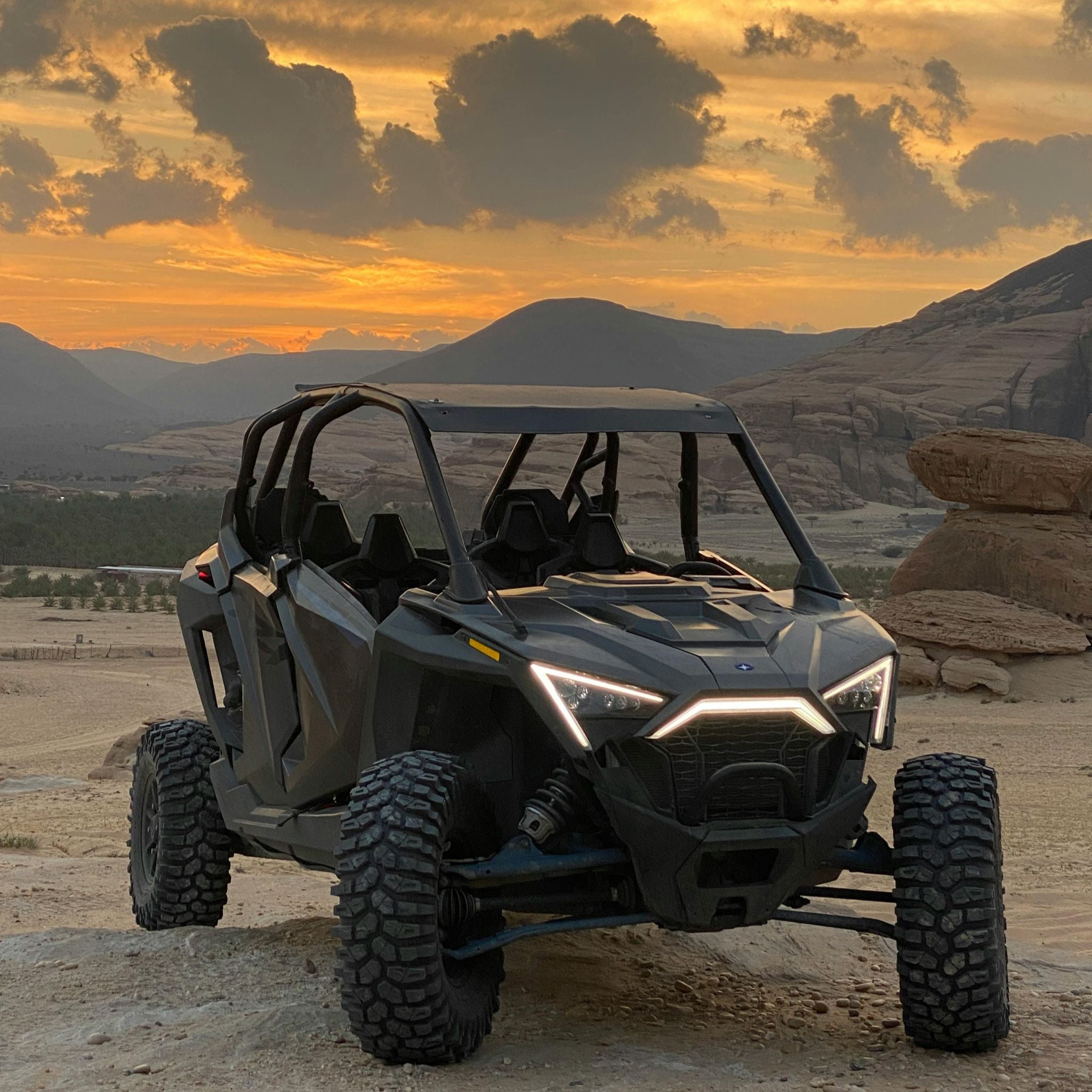 UTV on a desert landscape with a sunset sky.
